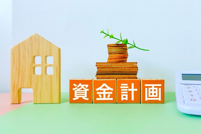 資金計画と木製の住宅模型