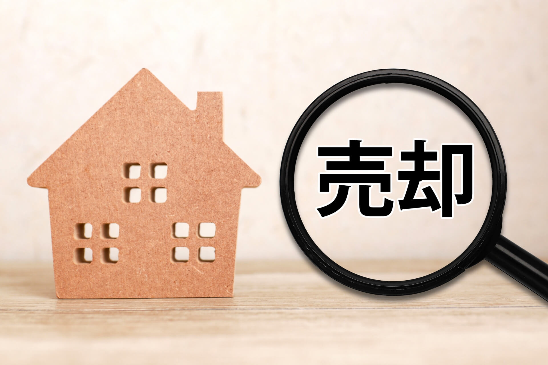 売却を示す木製の家と拡大鏡